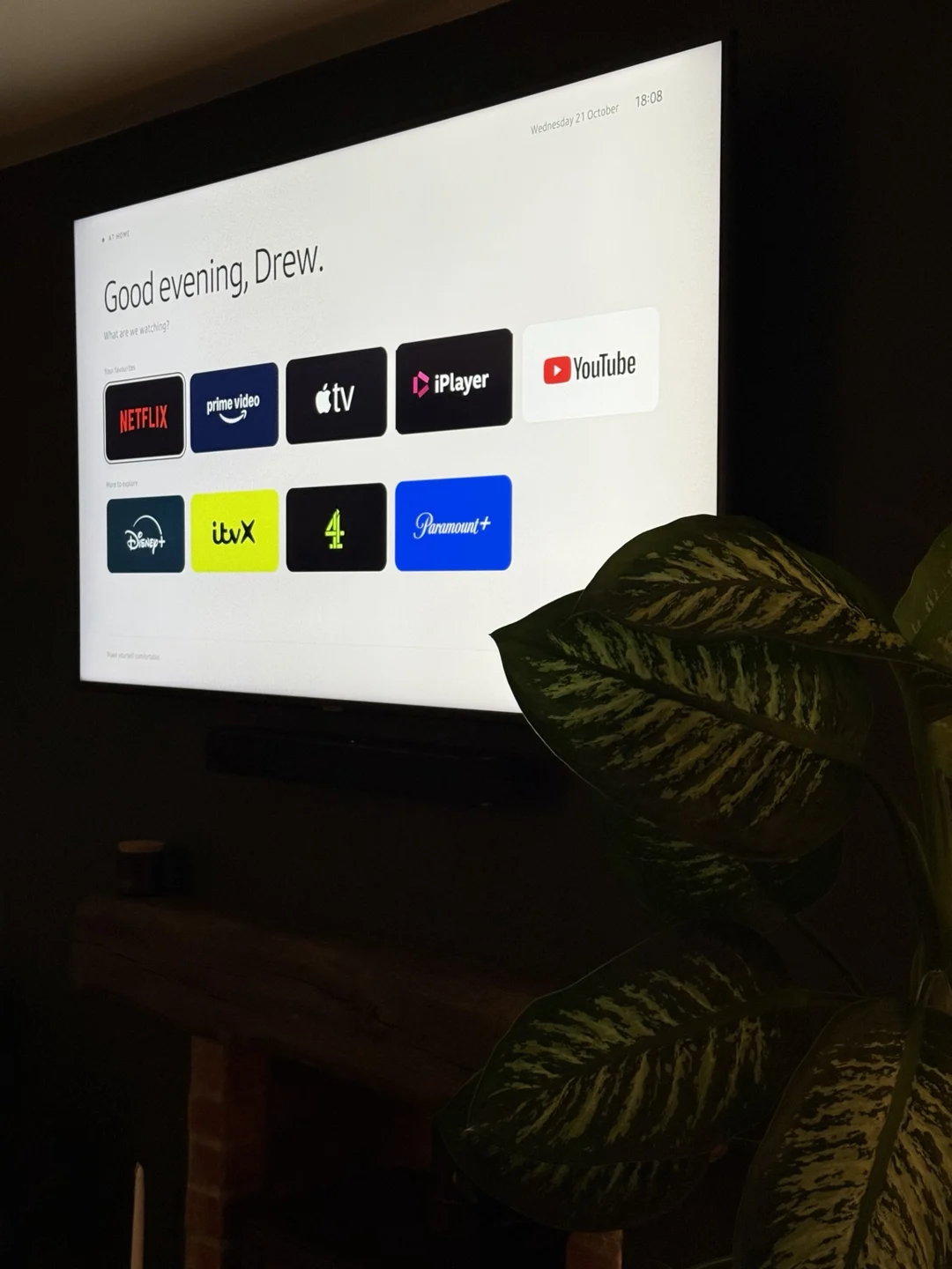 Final DrewTV launcher running on the TV with uniform tiles, accurate service logos and a Good evening, Drew greeting